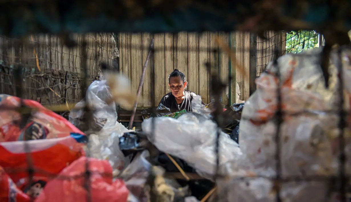 Seorang pekerja memilah sampah plastik yang dikumpulkan di sebuah depo dari 660 bank sampah di seluruh Surabaya, Jawa Timur pada 17 Juni 2025. (JUNI KRISWANTO/AFP)