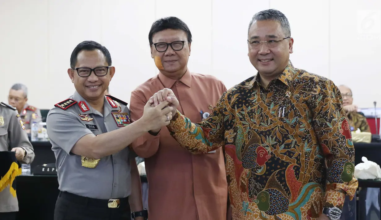 Kapolri Jenderal Pol Tito Karnavian bertumpu tangan bersama Mendagri Tjahjo Kumolo dan Mendes Eko Putro Sandjojo usai penandatanganan nota kesepahaman (MoU) mengenai dana desa di gedung Rupatama Mabes Polri, Jumat (20/10). (Liputan6.com/Angga Yuniar)