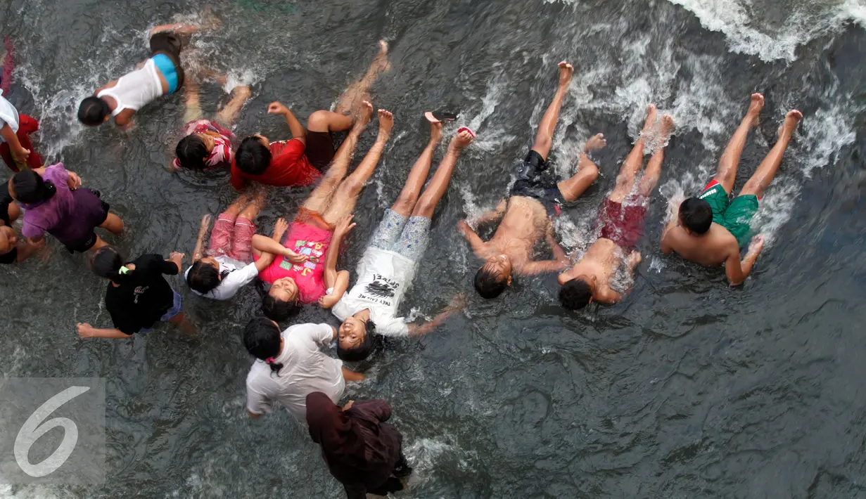 Warga menonton lomba sambil berbaring di Kali Code, Yogyakarta, Selasa (9/8). Lomba diselenggarakan untuk menyambut HUT RI ke-71. (Liputan6.com/Boy Harjanto)