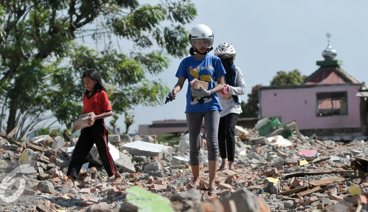 Sejumlah warga mengumpulkan batu bata merah dari sisa puing-puing rumah pembongkaran di Bukit Duri, Jakarta, Kamis (29/9). Batu bata merah yang dikumpulkan akan kembali dijual oleh warga dengan harga yang sangat murah. (Liputan6.com/Yoppy Renato)