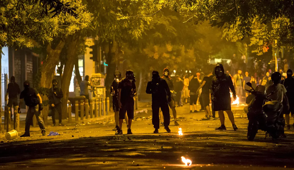 Para pemuda bentrok dengan polisi usai pengumuman hasil referendum di sepanjang jalan pusat kota Athena, Yunani, (6/7/2015). Yunani Saat ini berstatus negara bangkrut, karena tidak bisa membayar utang-utangnya. (REUTERS/Marko Djurica)
