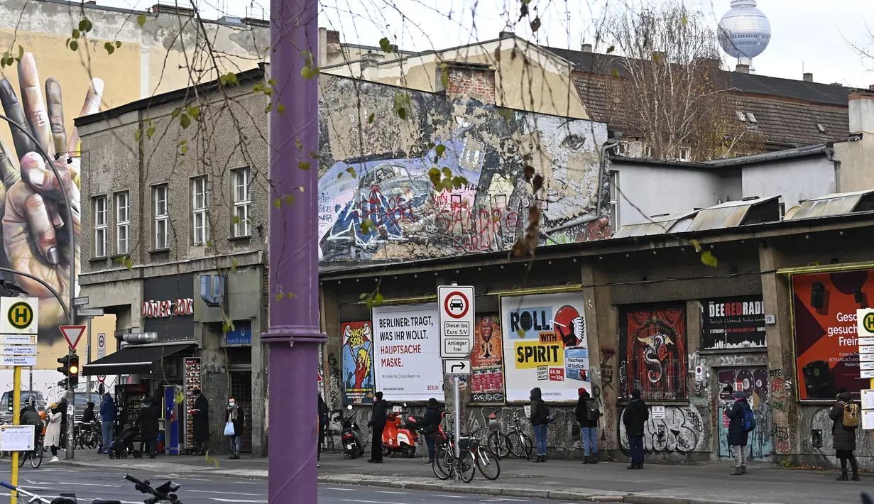 Orang-orang antre untuk melakukan tes usap (swab test) COVID-19 di luar kelab malam KitKatClub yang legendaris di Berlin, Jerman, Jumat (4/12/2020). Ditutup selama delapan bulan terakhir karena pembatasan virus corona, kelab malam itu diubah menjadi pusat pengujian Covid-19. (Tobias SCHWARZ/AFP)