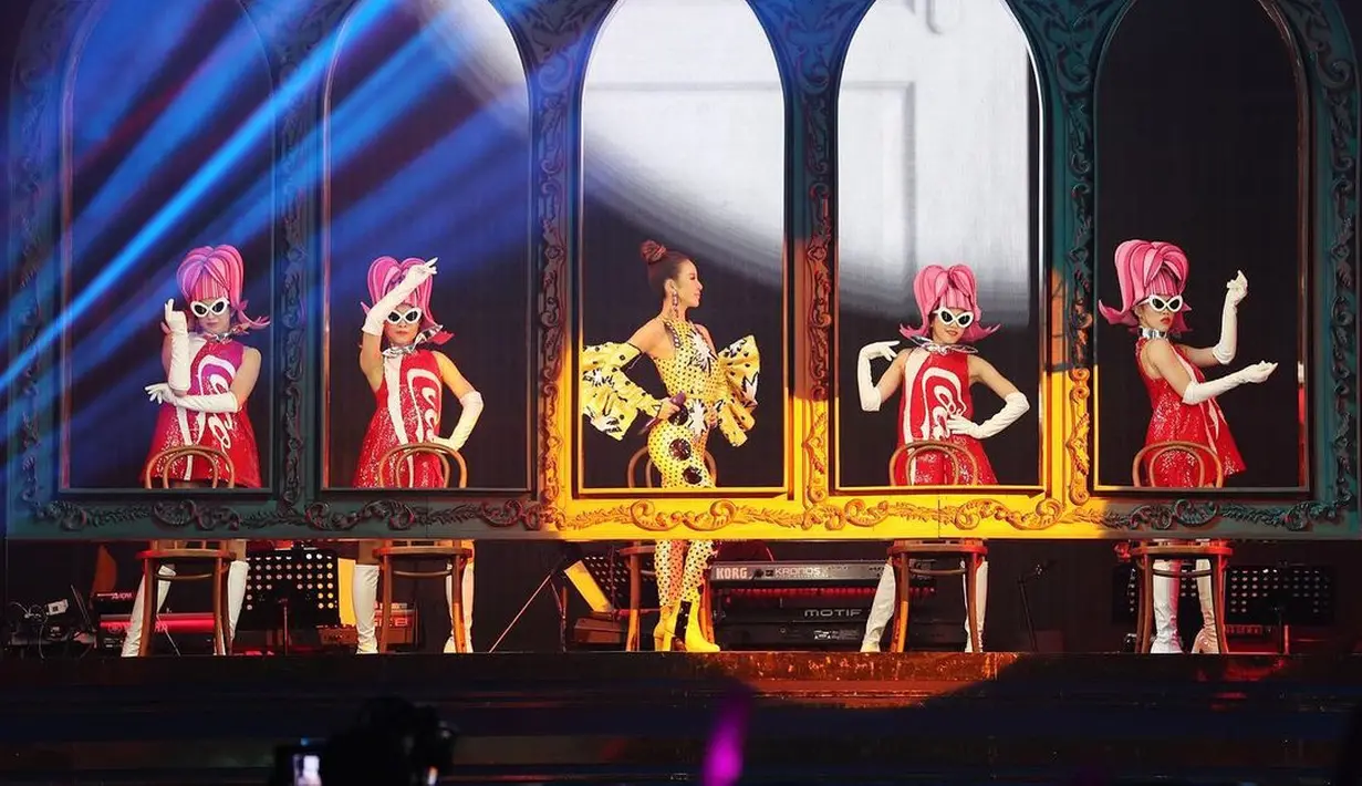 Momen lain memperlihatkan Coco yang tampil centil dengan jumpsuit nuansa kuning yang dilengkapi dengan ruffle long gloves.