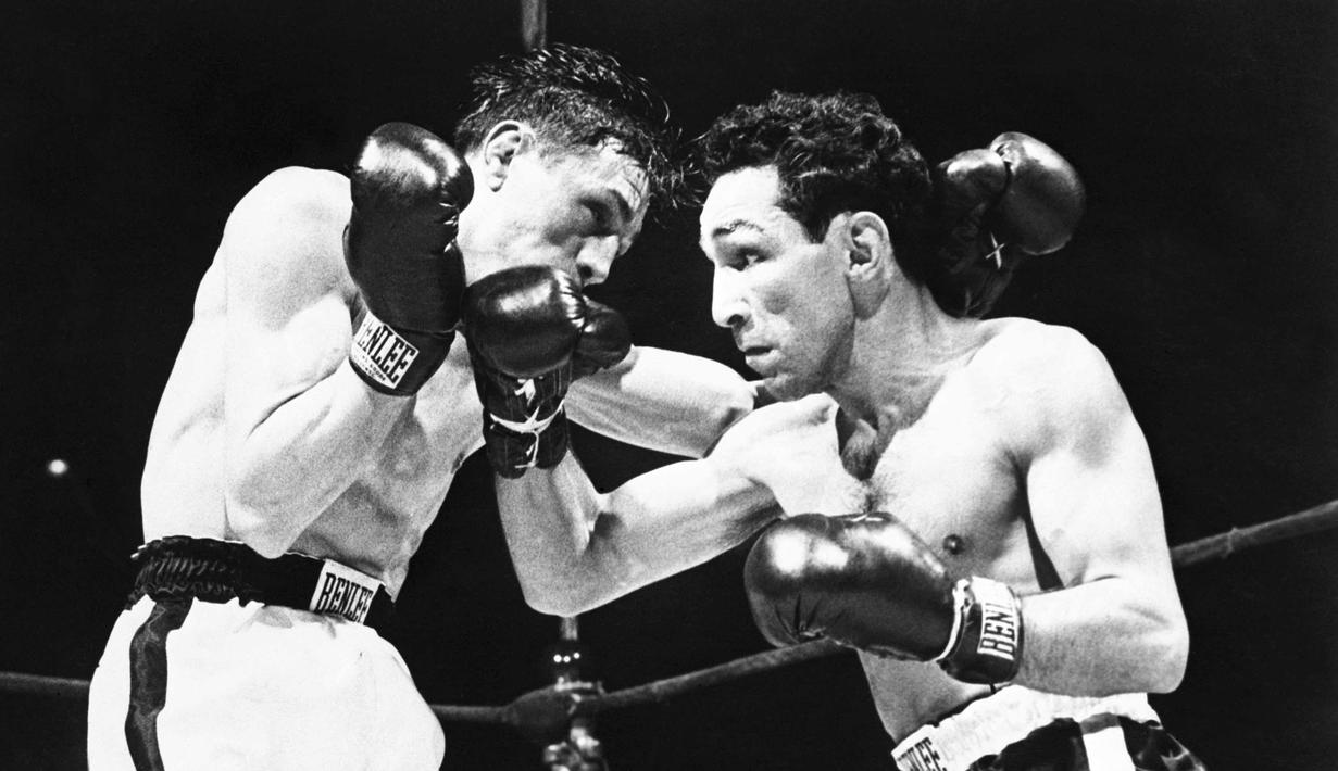 Willie Pep (kanan) memiliki rekor 229 kemenangan (65 KO) dan kalah 11 kali. Willie adalah juara kelas bulu pertama di dunia. Ini adalah saat Willie melawan petinju Prancis, Raymond Famechon di Madison Square Garden, New York, AS. (AFP/Intercontinentale)