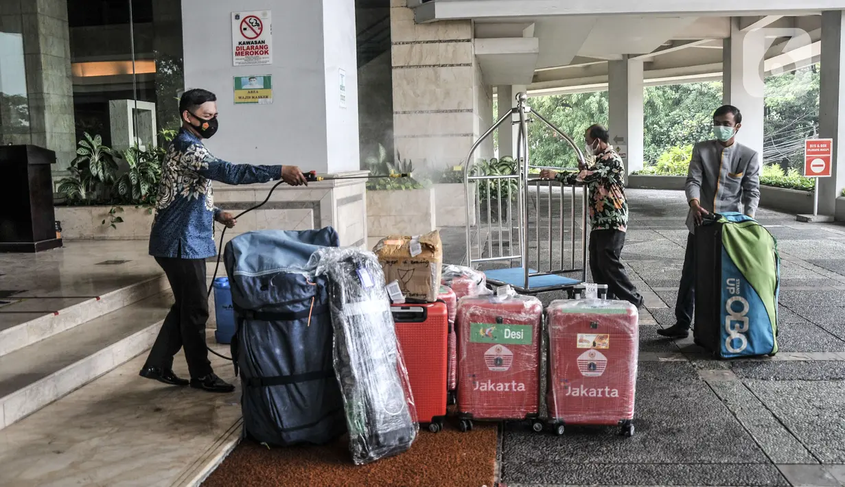 Petugas menyemprotkan cairan disinfektan pada barang-barang milik atlet kontingen DKI Jakarta saat tiba di Hotel Grand Cempaka Business, Jakarta, Kamis (14/10/2021). Nantinya para atlet ini akan menjalani tes swab PCR secara rutin tiap harinya serta tes malaria. (merdeka.com/Iqbal S. Nugroho)