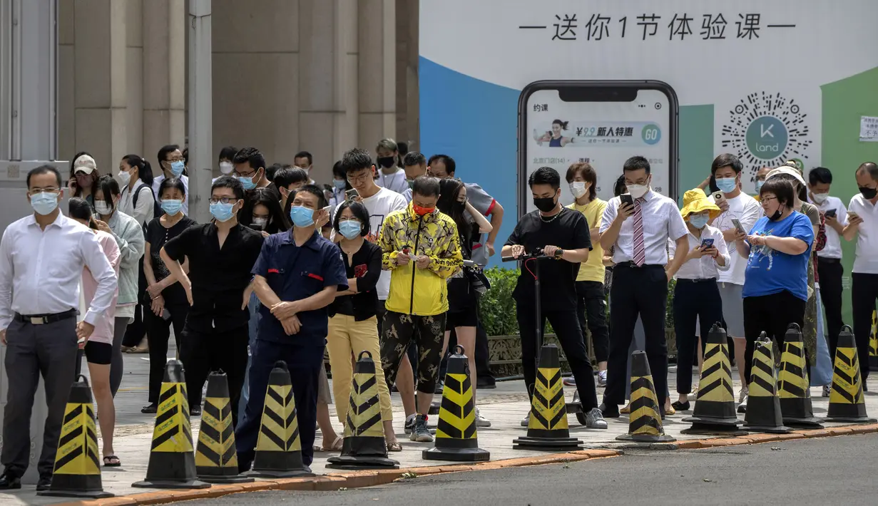 Orang-orang yang memakai masker mengantre di tempat pengujian virus corona COVID-19 pada hari ketiga tes massal untuk jutaan penduduk di Distrik Chaoyang, Beijing, China, 15 Juni 2022. (AP Photo/Mark Schiefelbein)