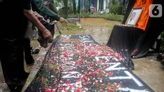Aktivis menabur bunga pada foto Bernardus Realino Norma Wirawan dalam pada peringatan 21 Tahun Tragedi Semanggi I di halaman Universitas Atma Jaya, Jakarta, Rabu (13/11/2019). Mereka menuntut kepada Presiden mengusut tragedi yang hingga kini belum ada kejelasan hukumnya. (Liputan6.com/Faizal Fanani)