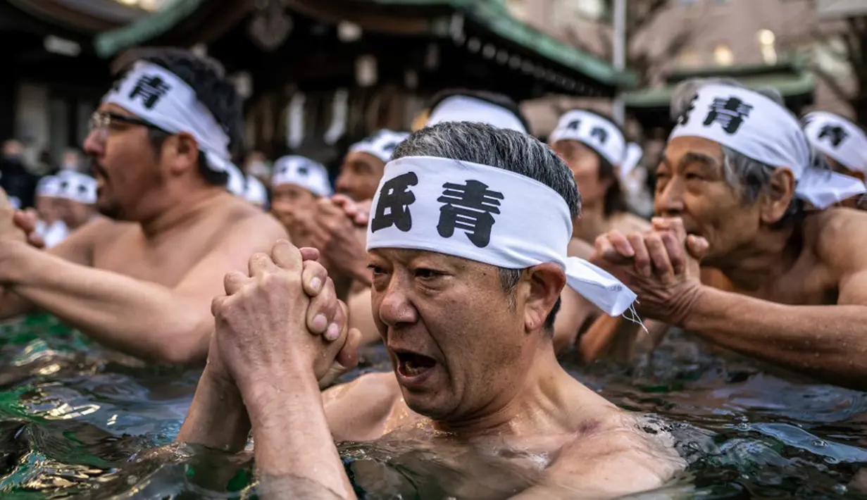 Penganut Shinto mandi dengan air dingin di Kuil Teppozu Inari, Tokyo, Jepang, 8 Januari 2023. Ritual Tahun Baru ini dilakukan untuk memurnikan jiwa dan raga. (Philip FONG/AFP)