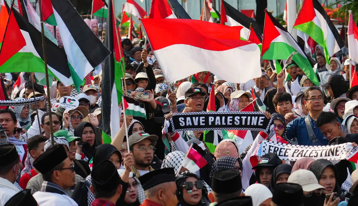 Para demonstran mengibarkan bendera Indonesia dan Palestina selama aksi unjuk rasa solidaritas untuk warga Palestina di Gaza, di Jakarta, Minggu 12 Oktober 2025. (AP Photo/Tatan Syuflana)