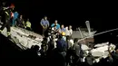 Petugas menyelamatkan bayi setelah gempa melanda pulau wisata di Ischia, di lepas pantai Napoli, Italia (21/8). Gempa berkekuatan 4.0 skala Richter (SR) membuat beberapa bangunan hancur. (AFP Photo/Mauro Pagnano)