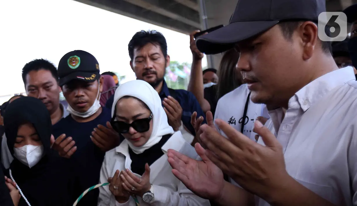 Sejumlah kerabat korban dan warga memanjatkan doa saat tabur bunga di lokasi kecelakaan maut di Jalan Transyogi, Cibubur, Bekasi, Jawa Barat, Rabu (20/7/2022). Aksi tabur bunga tersebut sebagai bentuk rasa duka cita atas meninggalnya 11 orang korban kecelakaan maut di kawasan tersebut. (Liputan6.com/Herman Zakharia)