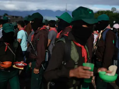Anggota Tentara Pembebasan Nasional Zapatista mengadakan makan malam dalam acara memperingati 30 tahun pemberontakan Zapatista di Dolores Hidalgo, Chiapas, Meksiko, Minggu (31/12/2023). (AP Photo/Eduardo Verdugo)