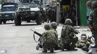 Pasukan pemerintah berlindung dari gempuran pasukan pemberontak muslim Moro National Liberation Front. (AFP/Ted Aljibe/wwn)