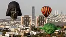 Balon udara dengan bentuk unik terbang selama Festival Balon Udara Internasional XVIII di  Leon, negara bagian Guanajuato, Meksiko pada 16 November 2019. Tak hanya balon udara biasa, banyak yang memiliki bentuk, serta warna unik menyemarakkan langit Kota Leon. (MARIO ARMAS / AFP)