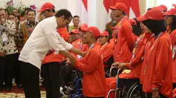 Presiden Joko Widodo memberikan bonus kepada atlet renang Asian Para Games 2018, Aris di Istana Bogor, Jakarta, Sabtu (13/10). Aris mendapat bonus sebesar Rp 500 juta karena memperoleh medali perunggu di Asian Para Games 2018. (Liputan6.com/HO/Randy)
