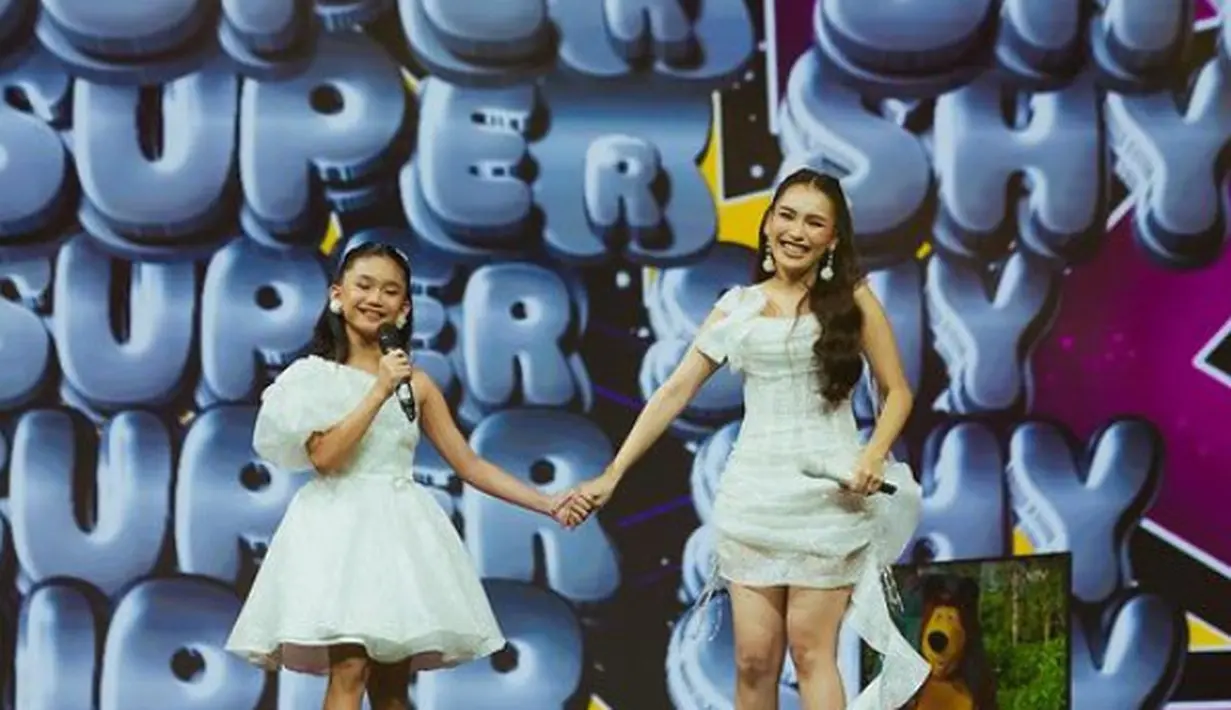 Bilqis pun tampil serasi dengan sang ibunda dengan mengenakan mini dress putih. Bilqis tampil dengan dress mengembang model one shoulder lengan pump. [@ayutingting92]