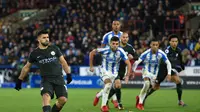 Striker Manchester City, Sergio Aguero, melepaskan tendangan penalti yang berujung gol ke gawang Huddersfield pada laga Premier League, di Kirklees Stadium, Minggu (26/11/2017). (AFP/Oli Scarff).