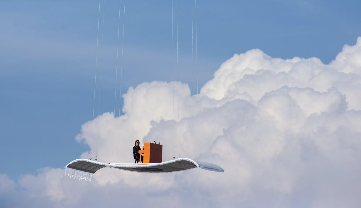 Pianis Jerman, Stefan Aaron memainkan piano di atas 'karpet terbang' yang diikatkan pada sebuah helikopter, Rabu (23/7/14). (REUTERS/Lukas Barth)