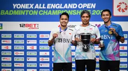 Peraih medali perak Anthony Sinisuka Ginting (kiri) dan peraih medali emas Jonatan Christie (kanan) merayakannya bersama pelatih mereka, Hendri Kurniawan Saputra di podium setelah bertanding di Final Tunggal Putra Kejuaraan Bulutangkis Terbuka All England di Utilita Arena, Birmingham, Inggris tengah, pada 17 Maret 2024. (JUSTIN TALLIS/AFP)