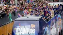 <p>Pemain Barcelona melakukan parade bus terbuka melalui Ibu Kota Catalan, menyapa para penggemar yang bernyanyi, dan melambai-lambaikan bendera sementara kembang api dan suar dinyalakan.&nbsp;(AP Photo/Joan Monfort)</p>