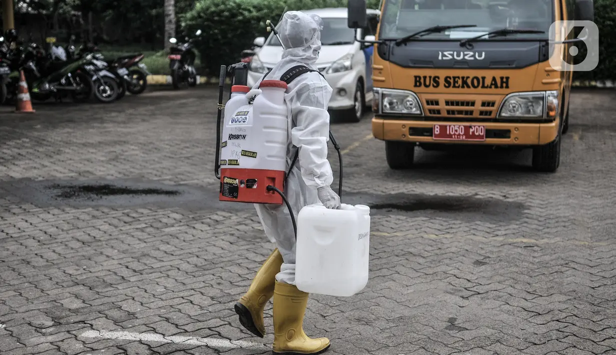 Petugas Kebersihan Bus (PKB) bersiap melakukan sterilisasi bus sekolah di Pool Unit Pelayanan Angkutan Sekolah (UPAS) DKI Jakarta, Kramat Jati, Selasa (5/1/2021). Sterilisasi bus sekolah rutin dilakukan usai digunakan mengangkut pasien terpapar Covid-19 ke RS rujukan. (merdeka.com/Iqbal Nugroho)