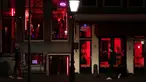 Orang-orang berjalan melewati rumah bordil di Red Light District Amsterdam, Belanda, Rabu (3/4). Red Light District merupakan kawasan prostitusi yang tersohor dan menjadi salah satu destinasi wisata di Belanda. (REUTERS/Yves Herman)