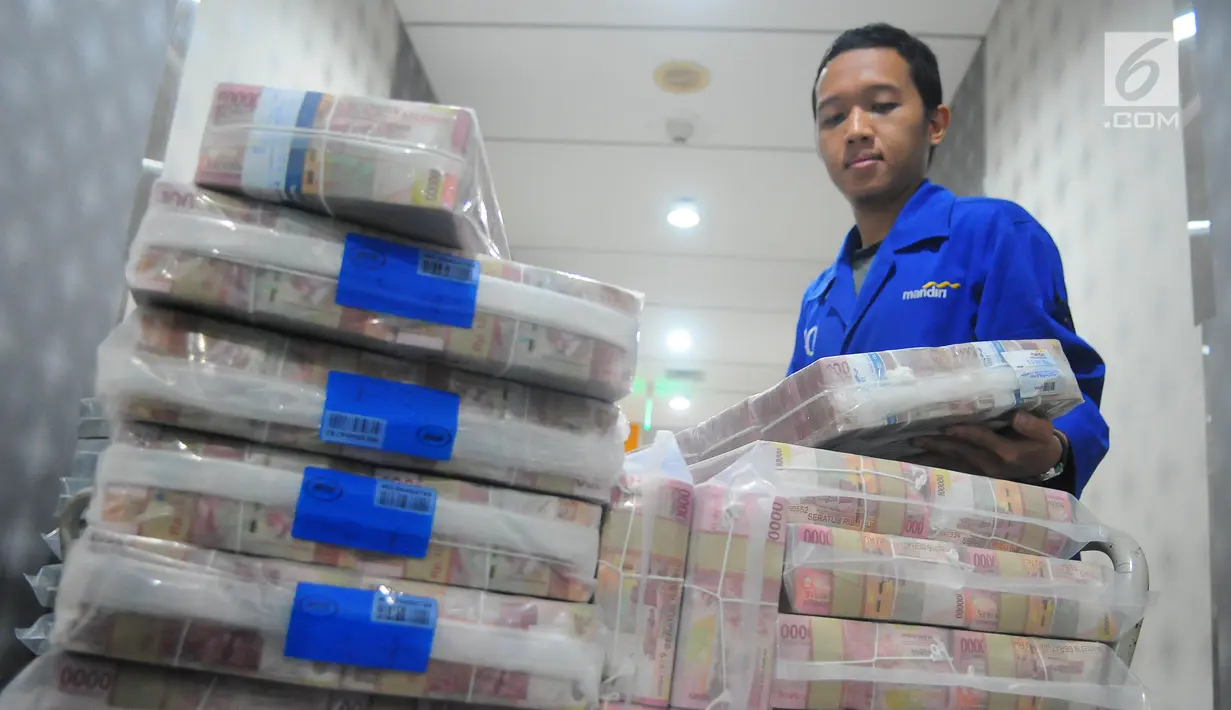 Karyawan memeriksa pasokan uang di Cash Pooling Bank Mandiri, Jakarta, Kamis (9/5/2019). Bank Mandiri menyiapkan dana tunai sebesar Rp 54,9 triliun pada Ramadan dan jelang Idul Fitri 2019. (Liputan6.com/Angga Yuniar)