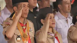 Presiden Joko Widodo bersama Ibu Negara Iriana memberi hormat saat mengikuti acara menghadiri perayaan hari jadi Pramuka yang ke-57 di Lapangan Gajah Mada, Wiladatika, Cibubur, Jakarta, Selasa (14/8). (Liputan6.com/Faizal Fanani)