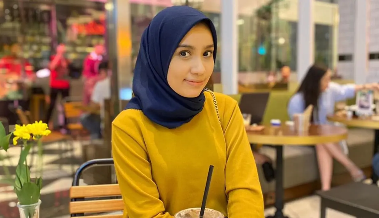 Saat hangout ke kafe bareng bestie, Amira lebih memilih bergaya simpel. Seperti pada potretnya kali ini. Istri pedangdut yang kini memiliki pengikut 33ribu lebih di Instagram itu memakai kaus berwarna gold, yang dipadukan dengan hijab navy. Polesan makeup-nya pun terlihat begitu natural. (Liputan6.com/IG/@amira_krmn)