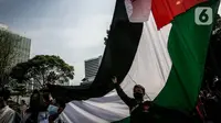 Massa yang tergabung dalam Aliansi Pemuda Indonesia untuk Palestina mengibarkan bendera Palestina saat aksi solidaritas di depan Kedutaan Besar Amerika Serikat, Jakarta, Selasa (18/5/2021). Massa mengajak masyarakat Indonesia untuk terus mendukung dan membantu Palestina. (Liputan6.com/Faizal Fanani)