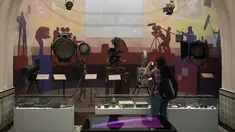 Seorang siswi mengambil gambar kamera tua dan peralatan pencahayaan yang dipajang di Museum Nasional Sinema India (NMIC), Mumbai, India (22/1). NMIC dibangun pemerintah dengan dana US$19,6 juta setara Rp277 miliar. (AFP Photo/Punitparanjpe)