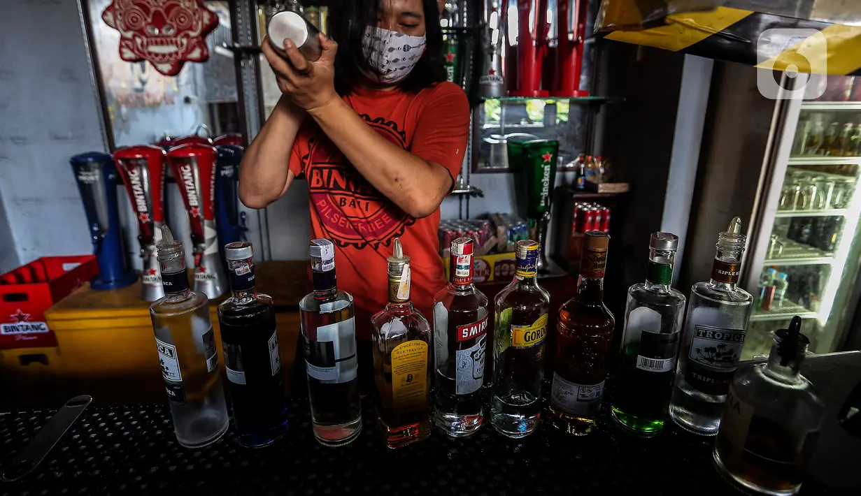 Pekerja menyiapkan minuman keras atau miras di mesin pendingin di salah satu kafe kawasan Jakarta Selatan, Selasa (2/3/2021). Aturan yang diteken oleh Presiden Joko Widodo pada 2 Februari 2021 terkait memperbolehkan masyarakat untuk berinvestasi di produk miras dicabut. (Liputan6.com/Johan Tallo)