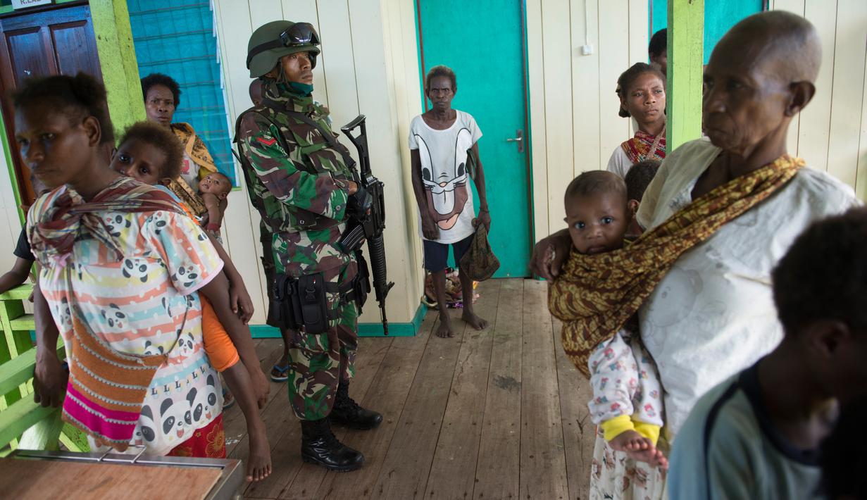 Seorang perwira militer berjaga di klinik setempat di desa Ayam distrik Asmat, di provinsi Papua Barat (26/1). Menurut Komandan Korem 174/ATW Merauke ini, jumlah anak yang meninggal akibat wabah campak dan gizi buruk tercatat 70 orang. (AFP/Bay Ismoyo)
