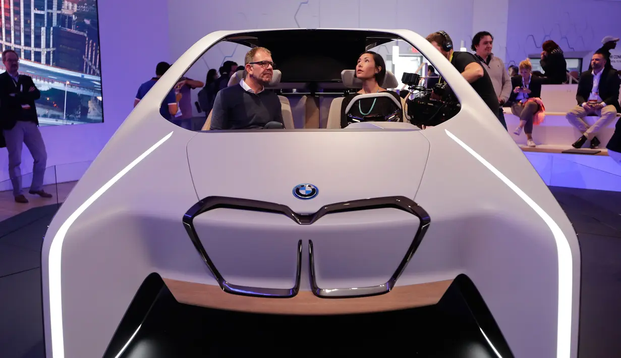 Holger Hampf bersama seorang reporter duduk di mobil konsep masa depan BMW, i Inside Future, dalam ajang CES 2017 di Las Vegas, 5 Januari 2017. Didesain dengan kapasitas empat penumpang, bagian head rest dibuat bergelantung di atap. (AP Photo/Jae C. Hong)