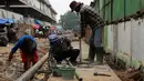 Para pekerja saat melakukan revitalisasi saluran air di kawasan Pasar Kramatjati, Jakarta, Jumat (23/10/2015). Hampir seluruh atap di lantai satu dan dua pasar ini sudah rusak dan keropos. (Liputan6.com/Yoppy renato)