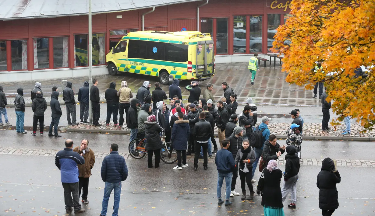 Warga berkerumun pasca terjadinya penyerangan di sebuah sekolah di Trollhattan, Swedia barat, Kamis (22/10). Seorang murid dan guru tewas akibat diserang pria bertopeng dan bersenjatakan pedang. (REUTERS/Bjorn Larsson Rosvall/TT News Agency)