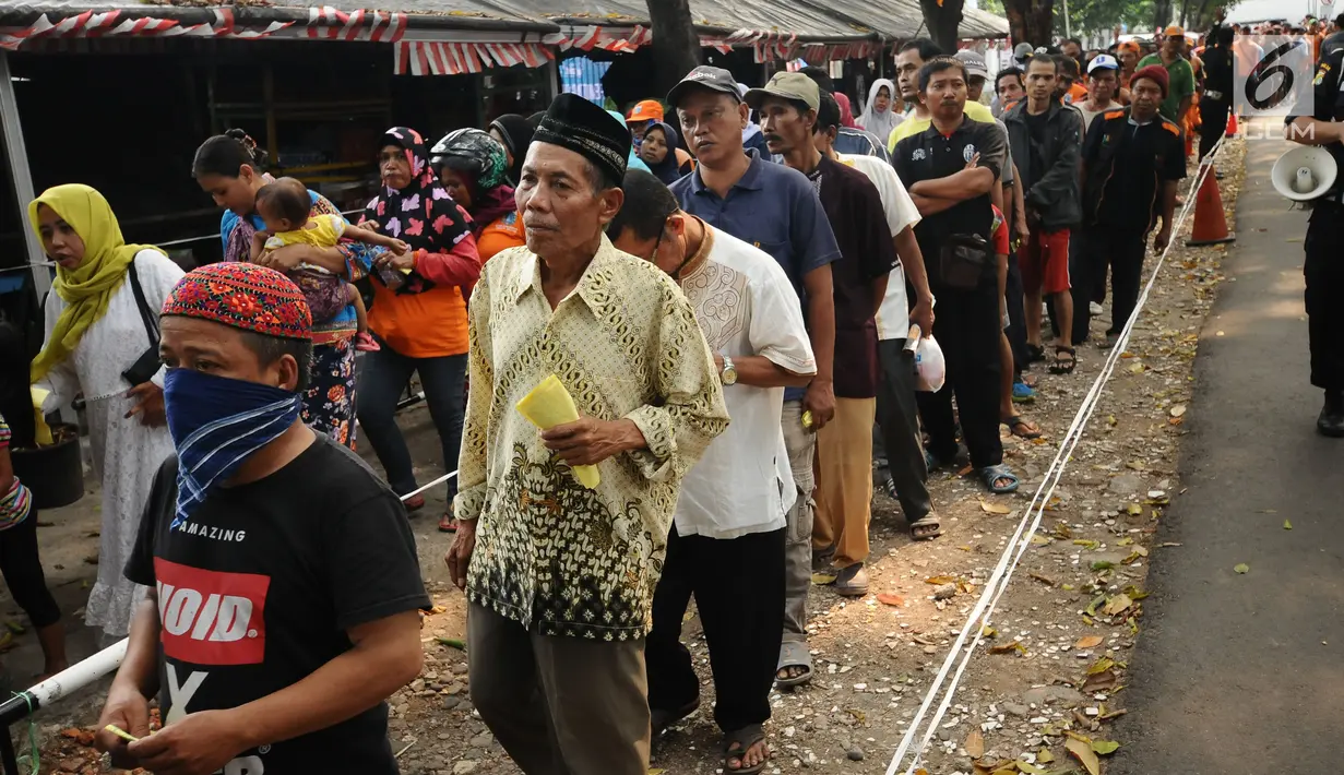 Warga antre saat pembagian daging kurban di sekitar Masjid Al Azhar, Jakarta, Jumat (1/9). Masjid Al Azhar Jakarta memotong dan mendistribusikan ratusan hewan kurban pada Hari Raya Idul Adha 1438 H. (Liputan6.com/Helmi Fithriansyah)