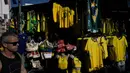 Seorang pria berjalan melewati kaus tim sepak bola nasional Brasil yang dipajang di pasar Saara, Rio de Janeiro, Brasil, pada Selasa 9 Juni 2026, menjelang turnamen Piala Dunia FIFA 2026. (Nelson ALMEIDA/AFP)