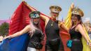 Tiga wanita berkostum unik berpose saat hari ketiga Festival Glastonbury di Worthy Farm, Somerset, Inggris (28/6/2019). Gelombang panas yang melanada bagian-bagian Eropa tidak menyurutkan pengunjung untuk berkumpul di festival ini. (AP Photo/Joel C Ryan)