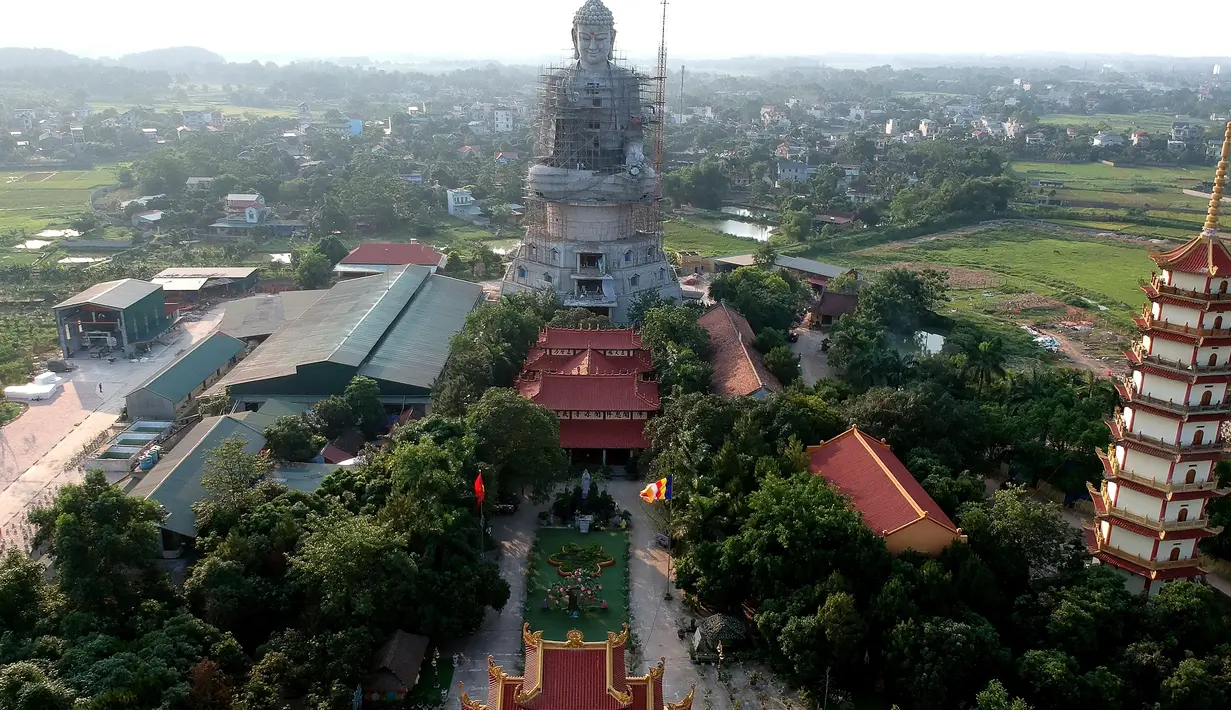 Foto udara pada 18 Mei 2019 memperlihatkan patung Buddha raksasa yang sedang dibangun di pagoda Khai Nguyen di distrik Son Tay, pinggiran Hanoi. Pengerjaan patung Buddha setinggi 72 meter ini dimulai pada 2015 dan diperkirakan selesai dalam lima tahun mendatang. (Photo by Manan VATSYAYANA/AFP)