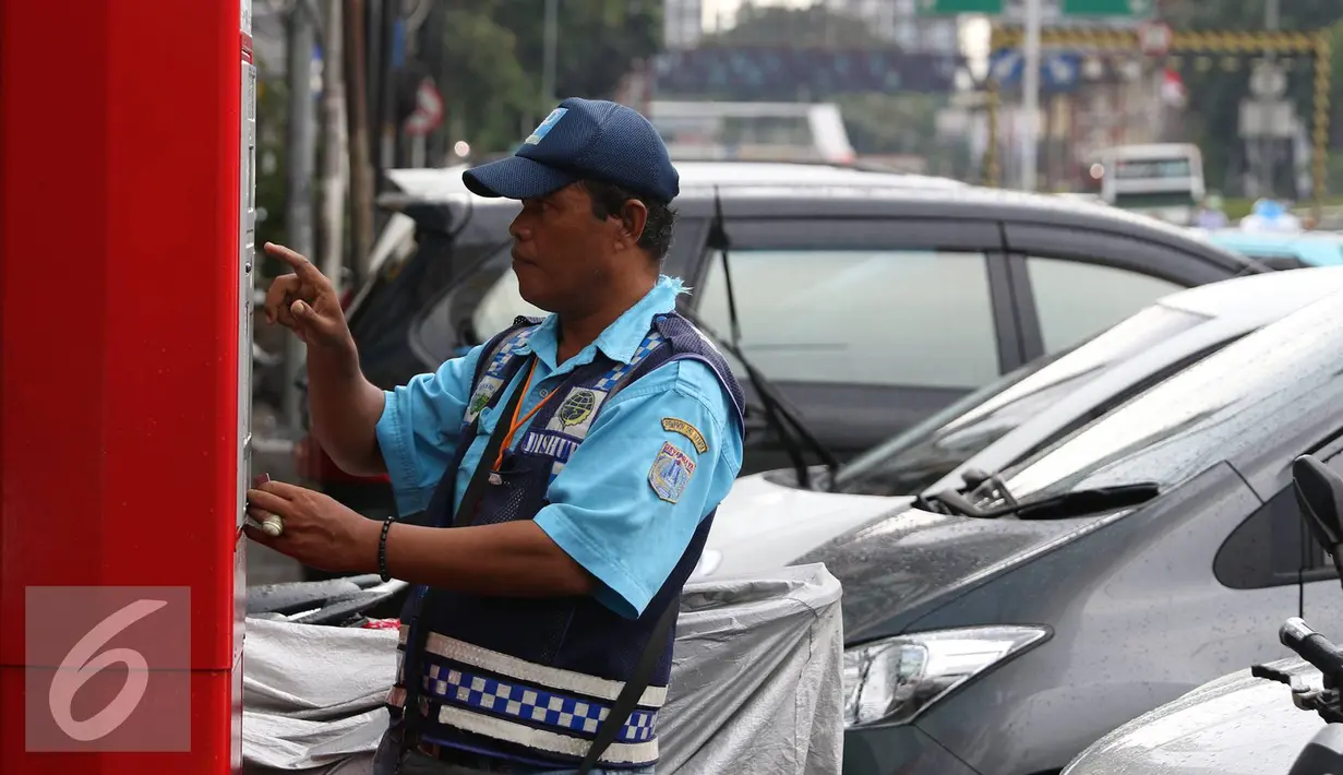 Petugas melakukan pembayaran pada mesin parkir meter di Jalan Falatehan, Jakarta, Selasa (1/11). Pemerintah sudah menggaungkan gerakan nasional nontunai (GNNT) kurang lebih sejak tiga tahun terakhir. (Liputan6.com/Immanuel Antonius)
