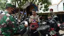 Anggota TNI membagikan masker kepada warga di Pasar Jatinegara, Kamis (10/9/2020). Petugas gabungan terus melakukan himbauan untuk memakai masker dan membagikan masker di pasar tersebut. (merdeka.com/Imam Buhori)