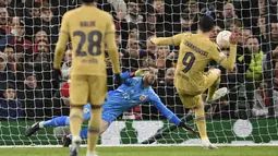 Striker Barcelona, Robert Lewandowski (kanan) menendang bola dari titik penalti yang membuahkan gol dalam pertandingan leg kedua play-off babak gugur Liga Europa 2022/2023 melawan Manchester United yang berlangsung di Old Trafford, Jumat (24/2/2023) WIB. (AFP/Oli Scarff)