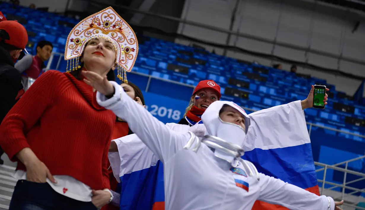 Fans wanita Rusia menunggu dimulainya pertandingan hoki es semifinal antara Republik Ceko dan Rusia selama Olimpiade Musim Dingin Pyeongchang 2018 di Gangneung Hockey Centre di Gangneung pada (23/2). (AFP Photo/Brendan Smialowski)