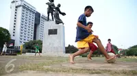 Anak-anak asyik bermain bola di Tugu Tani, Jakarta, Jumat (2/10/2015). Pemprov DKI Jakarta akan menambah ruang publik terpadu ramah anak (RPTRA) sebanyak 150 lokasi dengan menggunakan dana dari program CSR. (Liputan6.com/Faizal Fanani)