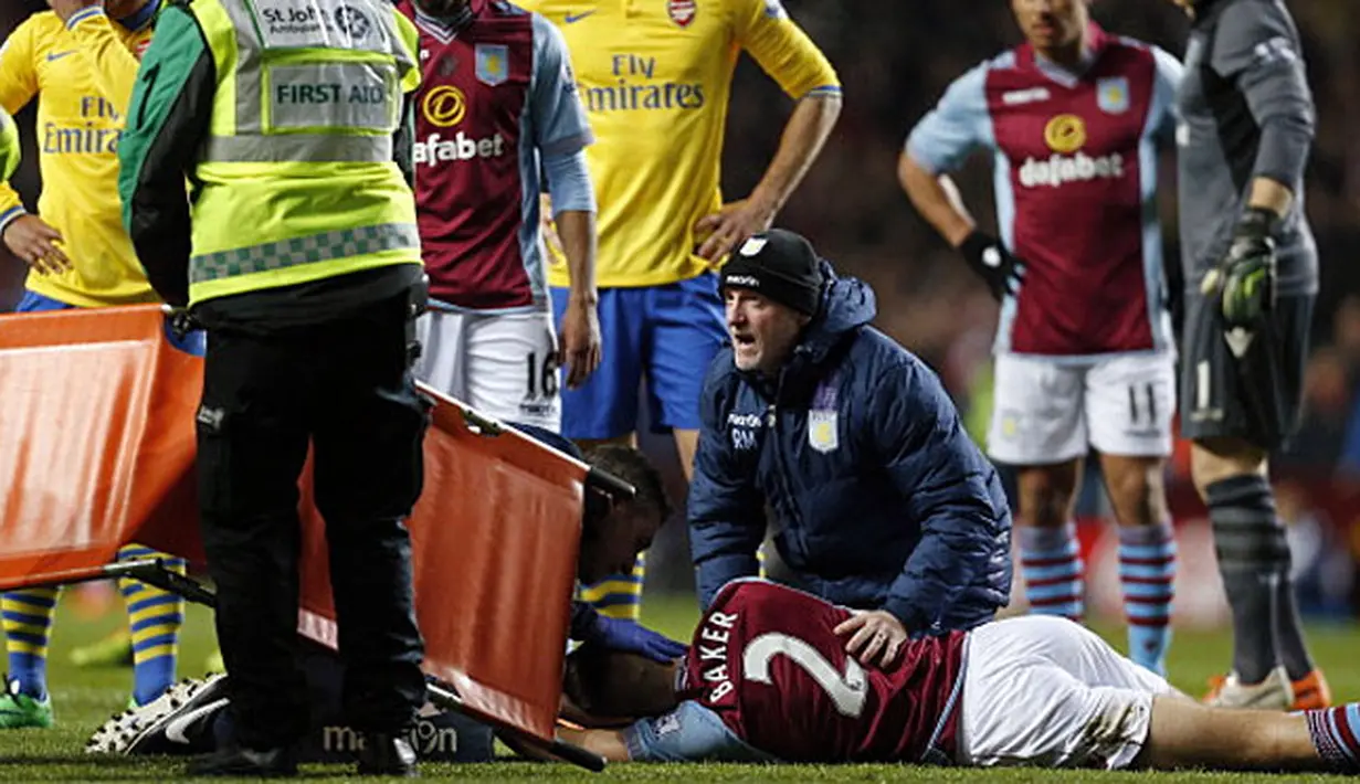 Pemain Belakang Aston Villa Nathan Baker (bawah) mengalami cedera saat laga pertandingan sepak bola Liga Utama Inggris antara Aston Villa melawan Arsenal di Villa Park, Birmingham, pada (13/01/14) waktu setempat. (Foto: AFP/Adrian Dennis)