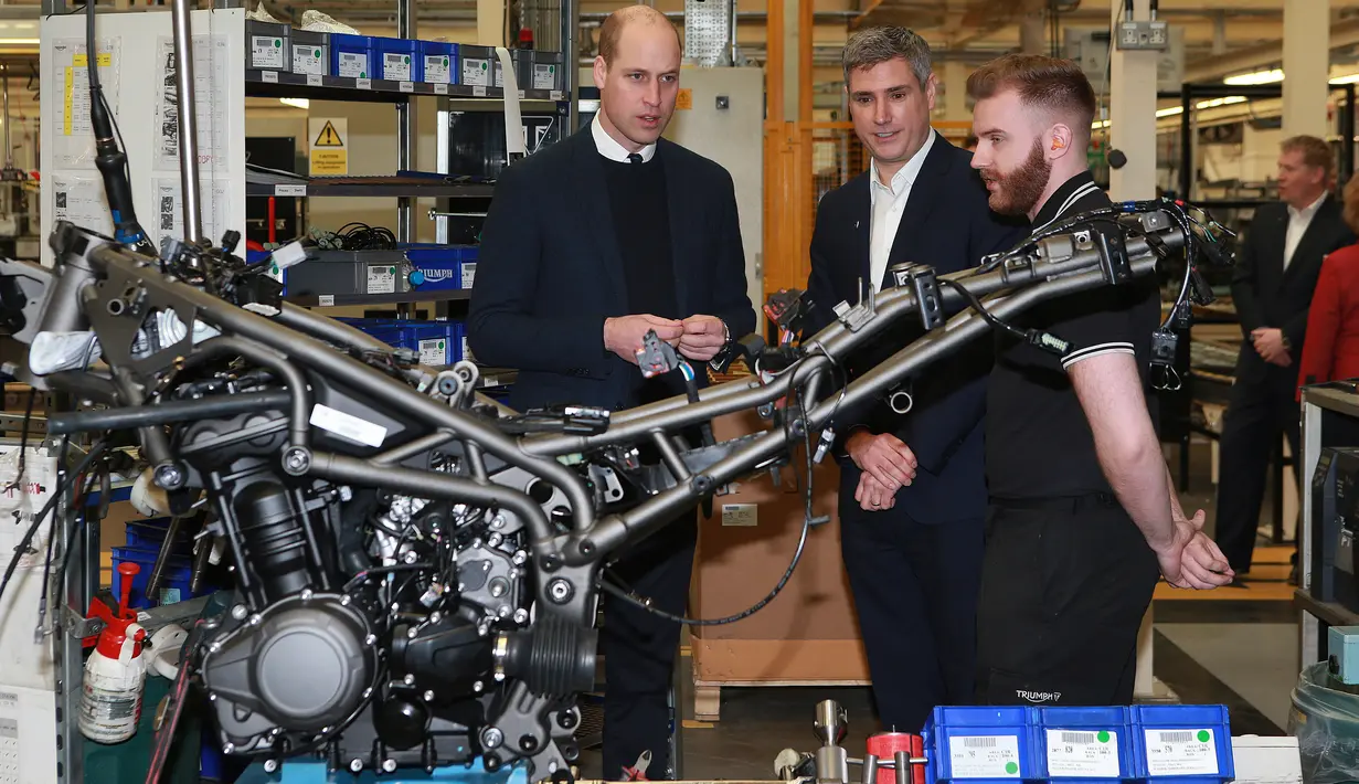 Pangeran William berbincang dengan teknisi perakitan motor Triumph dalam kunjungannya ke pabrik Triumph Motorcycles di Hinckley, Inggris, Selasa (20/2). Dalam kunjungannya itu, William menjajal motor Triumph Tiger 1200 terbaru. (Ian Vogler/Pool via AP)