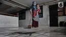 Warga saat menyapu debu batu bara yang mengotori depan rumahnya di Rusunawa Marunda, Jakarta Utara, Rabu (9/3/2022). Menurut warga rusun, pencemaran debu batu bara sudah berlangsung sejak 2019. (merdeka.com/Iqbal S. Nugroho)