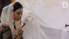 Ketua Dewan Kerajinan Nasional Daerah (Dekranasda) Kabupaten Trenggalek Jawa Timur mencanting kain batik tulis khas Trenggalek, pada pagelaran "Merayu Trenggalek Fashion Day 2022", di Museum Tekstil, Jakarta, Jumat (20/5/2021). Kegiatan yang bertepatan dengan Hari Kebangkitan Nasional merupakan upaya memperkenalkan pesona Trenggalek sebagai lokal wisata domestik Jawa Timur sekaligus mendongkrak UMKM pasca pandemi Covid-19. (Liputan6.com/Fery Pradolo)