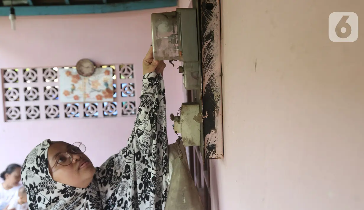 Warga memeriksa meteran listrik di kawasan Matraman, Jakarta, Kamis (2/4/2020). Pemerintah menggratiskan biaya tarif listrik bagi konsumen 450 Volt Ampere (VA) dan pemberian keringanan tagihan 50 persen kepada konsumen bersubsidi 900 VA mulai April hingga Juli 2020. (Liputan6.com/Herman Zakharia)
